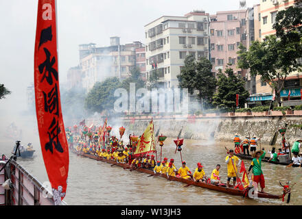 (190630) -- GUANGZHOU, June 30, 2019 (Xinhua) -- Rowers paddle the dragon boats in Chebei, Guangzhou, south China's Guangdong province, June 5, 2019. Chebei is an ancient village with a history of more than 1,000 years and over 200,000 permanent residents in Guangzhou, south China's Guangdong province. The Chebei Village Dragon Boat is listed as the intangible cultural heritage of Guangzhou. The Dragon Boat Festival consists of many key steps which has been preserved integrally.    On the eighth day of the fourth lunar month, the day of Lifting Dragon, dragon boats in Chebei, which has been co Stock Photo