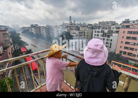 (190630) -- GUANGZHOU, June 30, 2019 (Xinhua) -- Villagers watch the rowers paddling the dragon boats in Chebei, Guangzhou, south China's Guangdong province, June 5, 2019. Chebei is an ancient village with a history of more than 1,000 years and over 200,000 permanent residents in Guangzhou, south China's Guangdong province. The Chebei Village Dragon Boat is listed as the intangible cultural heritage of Guangzhou. The Dragon Boat Festival consists of many key steps which has been preserved integrally.    On the eighth day of the fourth lunar month, the day of Lifting Dragon, dragon boats in Che Stock Photo