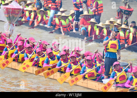 (190630) -- GUANGZHOU, June 30, 2019 (Xinhua) -- Rowers paddle the dragon boats in Chebei, Guangzhou, south China's Guangdong province, June 5, 2019. Chebei is an ancient village with a history of more than 1,000 years and over 200,000 permanent residents in Guangzhou, south China's Guangdong province. The Chebei Village Dragon Boat is listed as the intangible cultural heritage of Guangzhou. The Dragon Boat Festival consists of many key steps which has been preserved integrally.    On the eighth day of the fourth lunar month, the day of Lifting Dragon, dragon boats in Chebei, which has been co Stock Photo