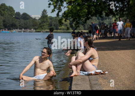 Tourists enjoy the sunshine at the Serpentine in Hyde Park, London. A the UK basks in 33C sunshine during hottest day of the year, 29th June 2019 Stock Photo