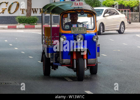 Bangkok, Thailand - April 13, 2019: Tuk tuk taxi driving on the streets of Silom district in Bangkok Stock Photo