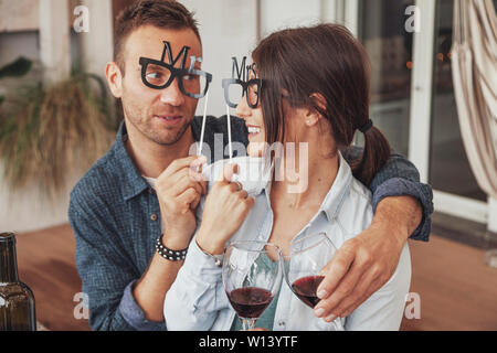 Couple of young lovers playing at the beginning of the love story and drinking red wine. Concept of happy relationship between boyfriends Stock Photo