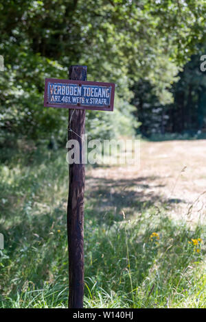 Old sign with the text no access in Dutch on a wooden pole at a nature reserve