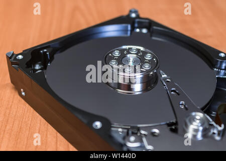 Computer hard drive without a cover, the mirror surface of the disk and parts Stock Photo