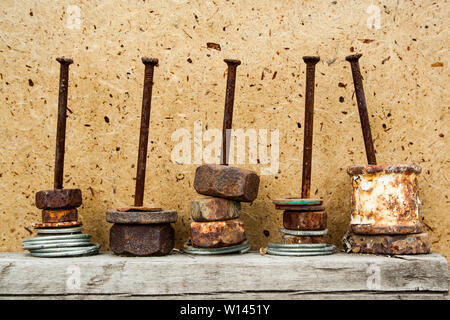 Organized old rusty nuts on grunge and aged nails on wooden background. Concept of hard work Stock Photo
