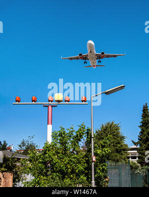 Easy jet plane with  flight path lights in Suburban garden. Aeroplane approaching Tegel airport & coming in to land, Berlin Stock Photo