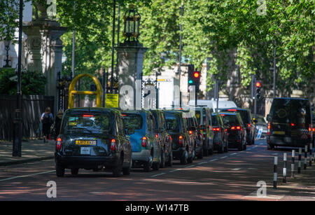 Long line of taxis at the western end of Birdcage Walk in central London, stopped at traffic lights Stock Photo