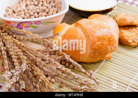 croissant baked bread with Milk in bowl soy bean in cup cookie and  spices on wooden bamboo. copy space for text. top view Stock Photo