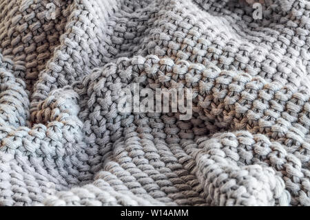 Abstract of a soft knit grey throw blanket with selective focus in center Stock Photo