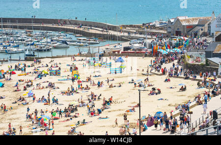 Lyme Regis, Dorset, UK. 30th June 2019. UK Weather: Warm sunny spells  and a refreshing breeze at the seaside resort of Lyme Regis.  Visitors relax on the sandy beach on Sunday afternoon as the June heatwave continues.  Credit: Celia McMahon/Alamy Live News Stock Photo