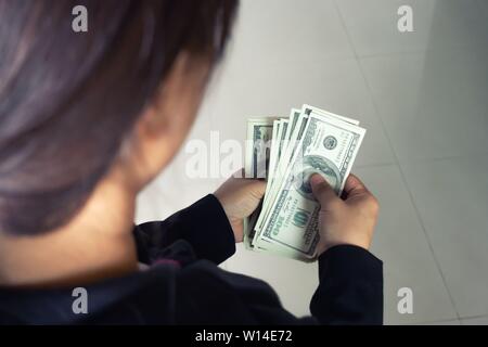 woman taking out money dollar banknotes from wallet Stock Photo