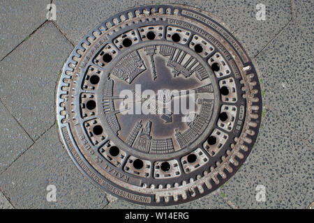 A manhole cover displaying a compilation of main sights in Berlin, Germany Stock Photo