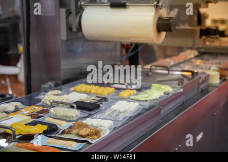 Linear tray food heat sealing and packaging machine Stock Photo