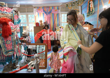 (190630) -- SINGAPORE, June 30, 2019 (Xinhua) -- Visitors try in traditional Chinese opera costumes during an event featuring Chinese opera held in Asian Civilisations Museum in Singapore, June 29, 2019. (Xinhua/Then Chih Wey) Stock Photo