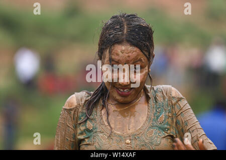 A woman covered in mud during a Festival.Farmers celebrate National Paddy Day Festival on 'Asar 15' of the Nepali calendar as the annual rice planting season begins. Stock Photo