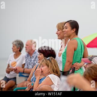 A small group of people watching a band perform at a Bands on the Beach Concert at Pensacola Beach, Florida USA Stock Photo