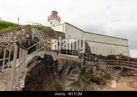 Youghal Lighthouse at low tide as seen from sea level with steps and railings mounted on rocks in Youghal, County cork, Ireland Stock Photo