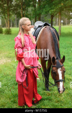 Russia, St. Petersburg, 08.13.2016. Beautiful girl with her andalusian horse and beautiful warm sunset in the autumn forest Stock Photo