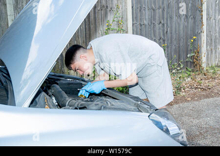 Teenage caucasian boy working on a car engine Stock Photo
