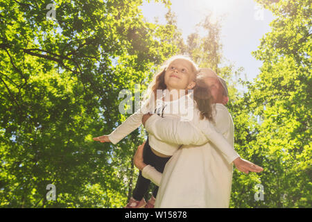 Happy young father plauing with child outside in park. Stock Photo