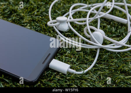 England, United Kingdom - June 30th 2019: Close up of USB-C Google Pixel Buds attahced to a Google Pixel 3 released by google an alphabet company in 2 Stock Photo