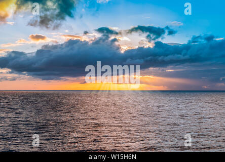 Cloudscape with sunset and sunbeam over the sea, Guadeloupe, Caribbean. Stock Photo