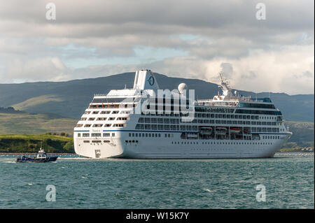 Bantry, West Cork, Ireland. 30th June, 2019. For the second time in a week, the cruise liner 'Nautica' spent the day anchored in Bantry Harbour.  She is pictured setting sail for Galway as the Whiddy Island Ferry passes, heading for Bantry. Credit: Andy Gibson/Alamy Live News. Stock Photo