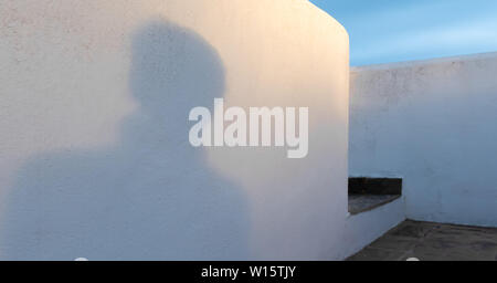 Persons shadow on a white wall with step Stock Photo