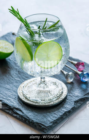 Gin and tonic cocktail with lime and rosemary - refreshing summer alkoholic drink Stock Photo