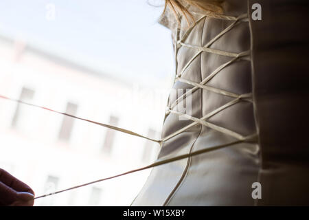 Bride from the back. Lacing the wedding dress. Stock Photo