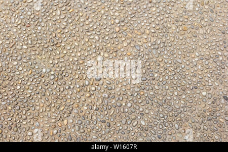 Small rounded stones in the ground. Stock Photo