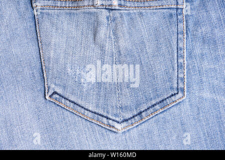 Blue denim. Cotton fabric, jeans. Creative vintage background. Pocket and zipper. The line is of poor quality. Cheap item Stock Photo