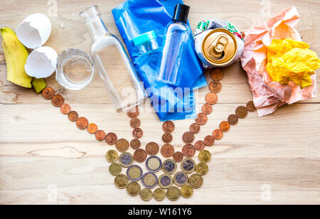 Different recycling materials trash on wood table: old paper, metal tin can, plastic bottles and bags, glass bottles and biodegradable waste. Turning Stock Photo