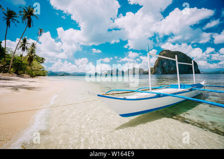 Impressive white cloudscape above picturesque sea shore with boat in El Nido, Palawan, Philippines. Wonderful nature