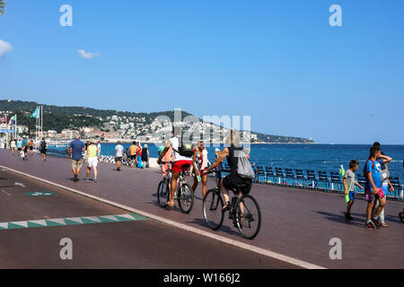 People strolling and cycling on Promenade des Anglais in Nice, France Stock Photo