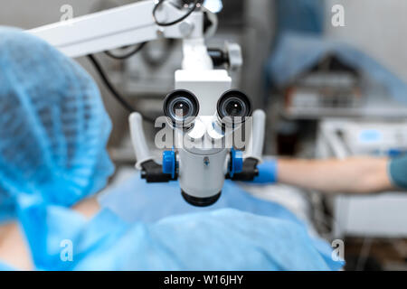 Vet ophthalmologist surgical microscope in operating room. and dog with injured eye on operating table, ready for operation. Stock Photo