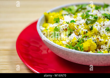 North Indian Food Poha in a bowl on a red plate Stock Photo