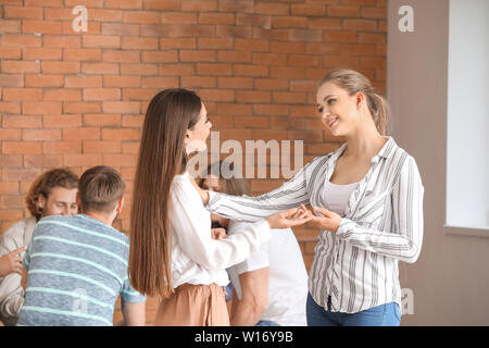 Young woman calming her friend at group therapy session Stock Photo