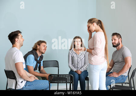 Young woman talking about her problems during group therapy Stock Photo