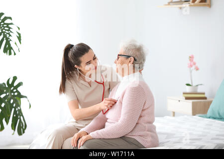 Doctor examining senior woman in nursing home Stock Photo