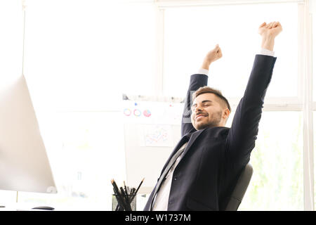 Handsome businessman having break during work in office Stock Photo