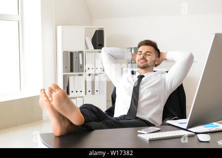 Handsome businessman having break during work in office Stock Photo