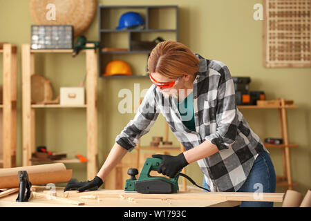 Female carpenter working in shop Stock Photo