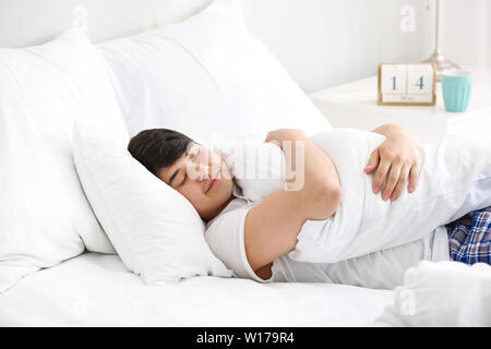 Handsome young man sleeping in bed Stock Photo