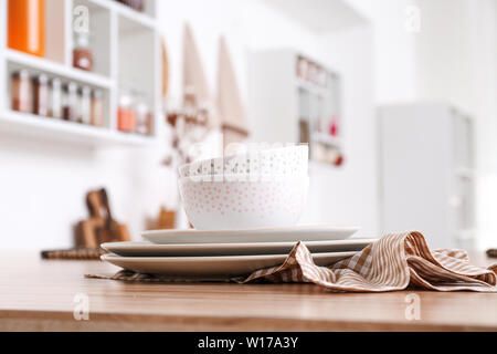 Stack of clean dishes on table in kitchen Stock Photo