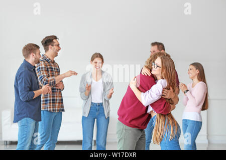 Young woman calming man at group therapy session Stock Photo
