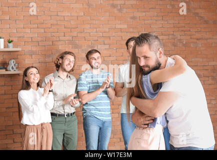 Young man calming his friend at group therapy session Stock Photo