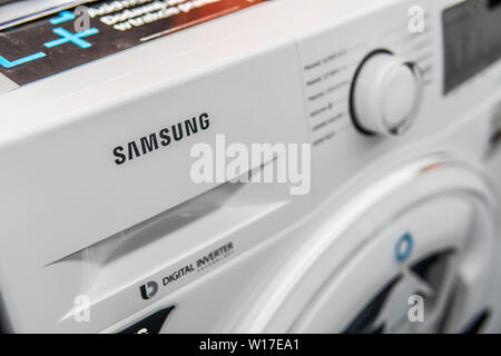 Lodz, Poland, July 2018 inside Saturn electronic store, free-standing Samsung washing machine on display for sale, produced by Samsung, logo, brand Stock Photo