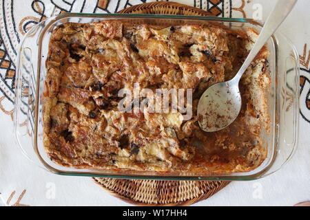 Chocolate Croissant Bread Pudding in a glass oven proof dish being served up. Stock Photo
