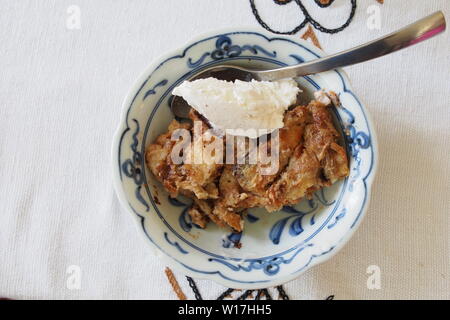 Chocolate Croissant Bread Pudding and vanilla ice cream in a blue china bowl. Stock Photo